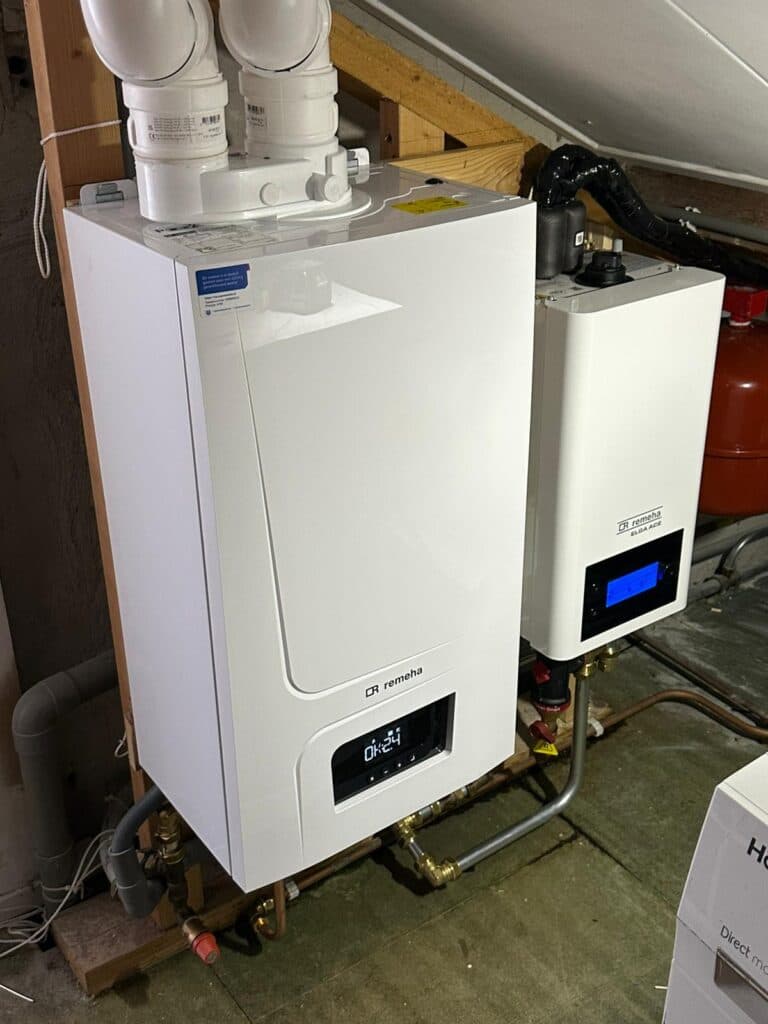 Buitenunit van een hybride warmtepomp tegen de gevel.