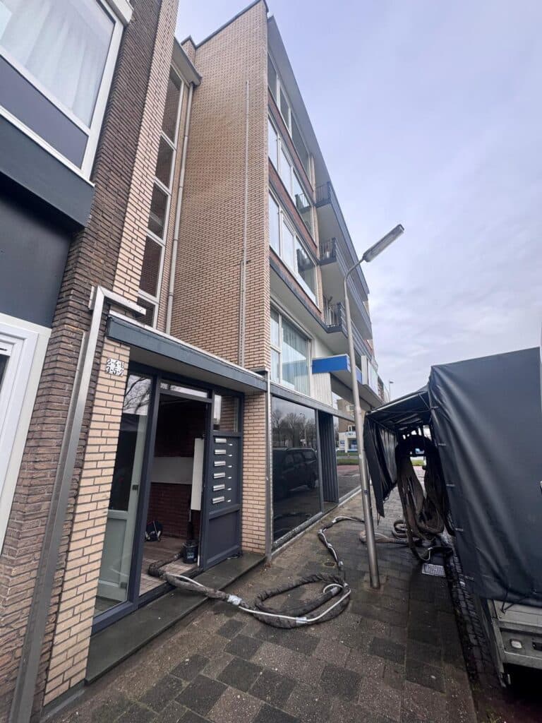 Gevel van een appartementencomplex tijdens het inblazen.